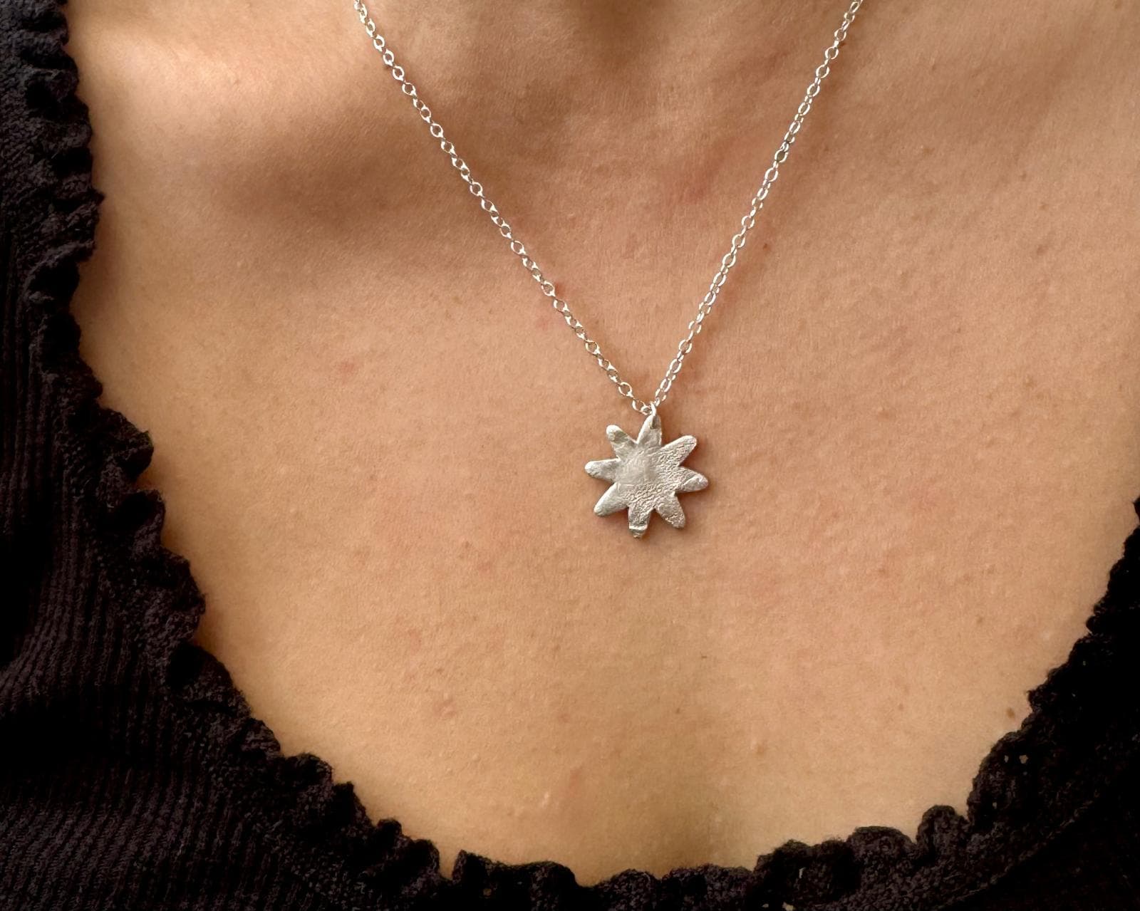 Nose-print keepsakes and a heart-shaped pendant on a wooden table